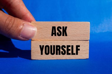 Kendine mavi arkaplanlı tahta bloklara yazılmış bir mesaj sor. Kavramsal olarak kendine bir sembol sor. Boşluğu kopyala.