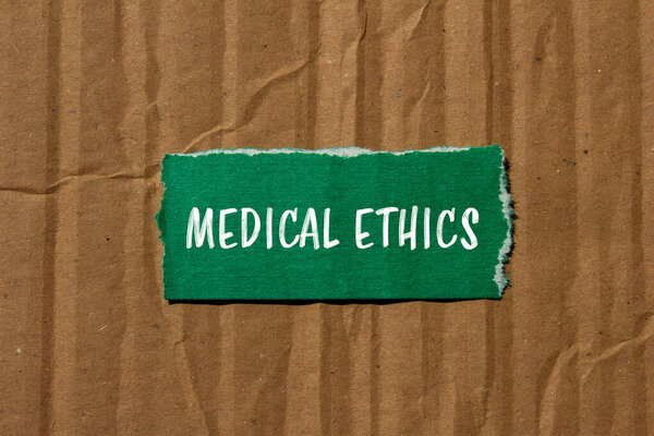 Медицинское этическое послание, написанное на разорванной зеленой бумаге с картонным фоном. Символ медицинской этики. Копирование пространства.