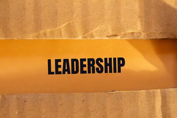 stock image Leadership message written on ripped torn cardboard paper with orange background. Conceptual leadership symbol. Copy space.