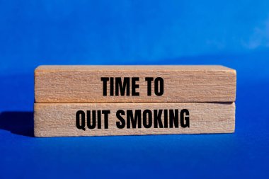 Ahşap bloklara mavi arka planda yazılmış sigara içme mesajını bırakma zamanı. Sigara içmeyi bırakmanın kavramsal zamanı. Boşluğu kopyala.