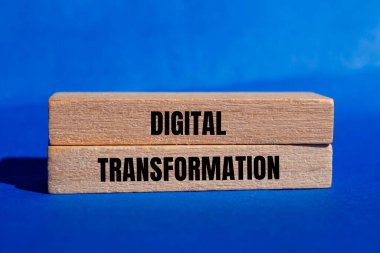 Mavi arka planlı tahta bloklara yazılmış dijital dönüşüm mesajı. Kavramsal dijital dönüşüm sembolü. Boşluğu kopyala.