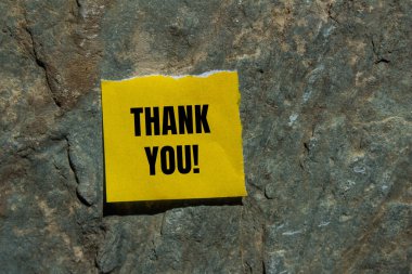 Yırtık sarı kağıt parçasına yazılan ve taştan arkaplanı olan mesaj için teşekkür ederim. Kavramsal teşekkür sembolü. Boşluğu kopyala.