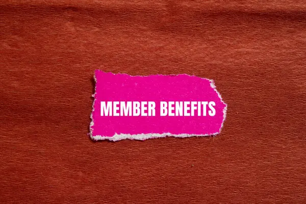 stock image Member benefits message written on ripped torn pink paper piece with brown background. Conceptual member benefits symbol. Copy space.