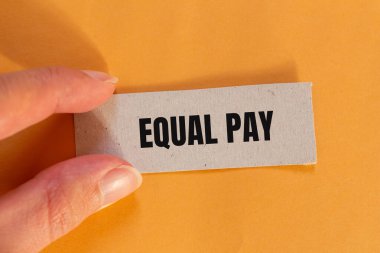 Turuncu arka planda yırtık kağıt parçasına eşit ödeme mesajı. Kavramsal eşit maaş sembolü. Boşluğu kopyala.