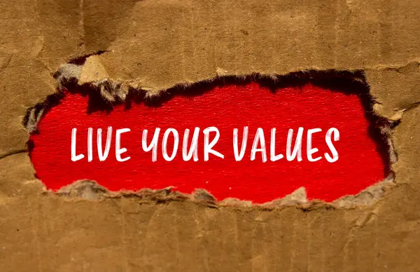 stock image Live your values message written on torn cardboard paper with red background. Conceptual live your values symbol. Copy space.