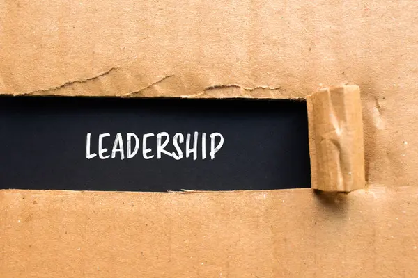 stock image Leadership message written on ripped torn cardboard paper with black background. Conceptual leadership symbol. Copy space.