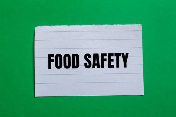 stock image Food safety message written on ripped torn paper piece with green background. Conceptual food safety symbol. Copy space.