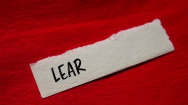 Kırmızı arkaplanda yırtık kağıt parçasına İngilizce mesaj yazmayı öğren. Kavramsal İngilizce öğrenme sembolü.