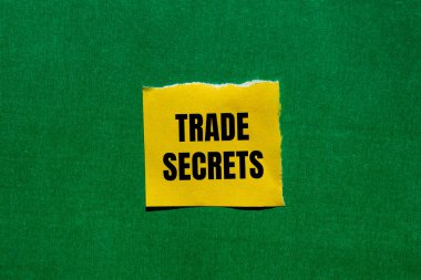 Yırtık sarı kağıt parçasına yeşil arkaplan ile yazılmış ticari sırlar mesajı. Kavramsal ticaret sırları sembolü. Boşluğu kopyala.