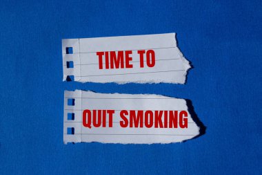 Yırtık kağıt parçalarına mavi arka plan ile yazılmış sigara içme mesajını bırakma zamanı. Sigara içmeyi bırakmanın kavramsal zamanı. Boşluğu kopyala.