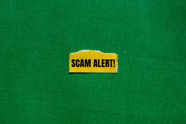 Yırtık sarı kağıt parçasına yeşil arkaplan ile yazılmış sahte uyarı mesajı. Kavramsal dolandırıcılık uyarı sembolü. Boşluğu kopyala.