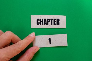 Chapter 1 message written on paper pieces with green background. Conceptual chapter 1 symbol. Copy space. clipart