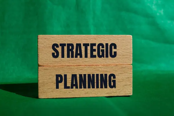 Stratejik planlama mesajı yeşil arka planlı tahta bloklara yazılmış. Kavramsal stratejik planlama sembolü. Boşluğu kopyala.