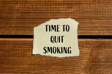 Yırtık kağıda ahşap zemin ile yazılmış sigara içme mesajını bırakma zamanı. Sigara içmeyi bırakmanın kavramsal zamanı. Boşluğu kopyala.