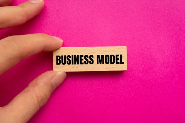 stock image Business model message written on wooden block with pink background. Conceptual business model symbol. Copy space.