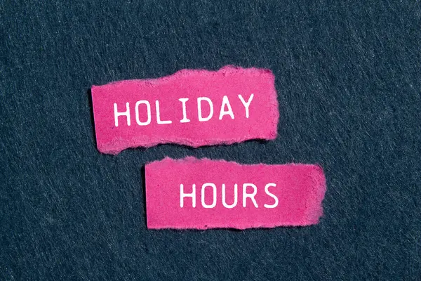 stock image Holiday hours message written on ripped pink torn paper pieces with gray felt background. Conceptual holiday hours symbol. Copy space.