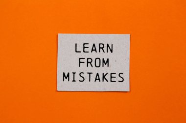 Turuncu arkaplanlı kağıt parçasına yazılmış hatalardan ders al. Hata sembolünden kavramsal öğrenim. Boşluğu kopyala.