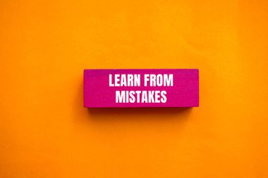 Pembe tahta blokta turuncu arka planda yazılan hatalardan ders al. Hata sembolünden kavramsal öğrenim. Boşluğu kopyala.