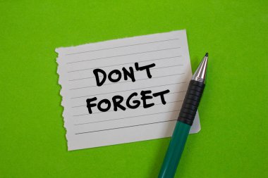 Yırtık kağıda yeşil arka planda kalemle yazılmış mesajı unutma. Kavramsal sembolü unutma. Boşluğu kopyala.