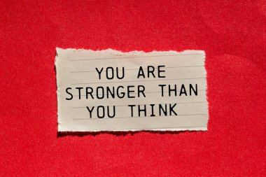 Kırmızı arka plandaki yırtık kağıt parçasına yazılmış mesajdan daha güçlüsün. Kavramsal olarak düşündüğünden daha güçlüsün. Boşluğu kopyala.