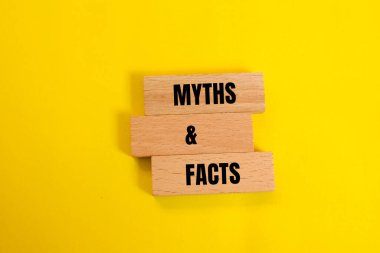 Efsaneler ve gerçekler sarı arka planlı tahta bloklara yazılmış bir mesaj. Kavramsal mitler ve gerçekler sembolü. Boşluğu kopyala.