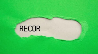 Gri arkaplandaki yırtık yeşil kağıda mesaj yazmaya devam et. Kavramsal kayıt sembolü.