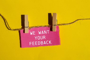 Sarı arkaplanlı pembe kağıt parçasına geri bildirim mesajını istiyoruz. Kavramsal olarak geri bildirim sembolünü istiyoruz. Boşluğu kopyala.