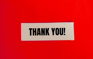 Kırmızı arkaplanlı kağıt parçasına yazılan teşekkür mesajı. Kavramsal teşekkür sembolü. Boşluğu kopyala.