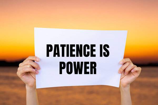 Терпение это энергетическое послание, написанное на белой бумаге с размытым фоном озера. Концептуальное терпение это символ силы. Копирование пространства.