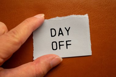 Kahverengi arka planda yırtık kağıt parçasına yazılan izin günü mesajı. Kavramsal kapalı gün sembolü. Boşluğu kopyala.