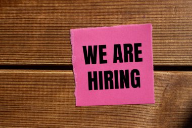 Tahta arka planda yırtık pembe kağıt parçasına yazılmış bir mesaj alıyoruz. Kavramsal olarak sembol kiralıyoruz. Boşluğu kopyala.