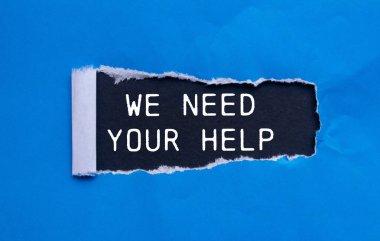 Siyah arkaplanlı yırtık mavi kağıda yazılmış yardım mesajına ihtiyacımız var. Kavramsal olarak yardım sembolüne ihtiyacımız var. Boşluğu kopyala.