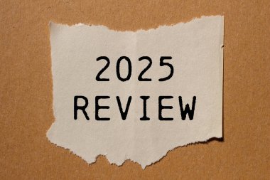 Yırtık kağıt parçasına kahverengi arkaplanlı 2025 gözden geçirme mesajı. Kavramsal 2025 değerlendirme sembolü. Boşluğu kopyala.