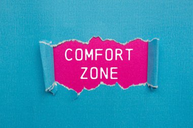 Pembe arkaplanlı yırtık mavi kağıda yazılmış rahat bölge mesajı. Kavramsal konfor bölgesi sembolü. Boşluğu kopyala.