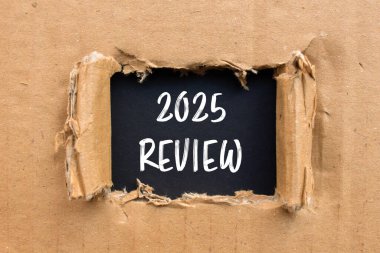Yırtık kart kağıdına siyah arkaplan ile yazılmış 2025 gözden geçirme mesajı. Kavramsal 2025 değerlendirme sembolü. Boşluğu kopyala.
