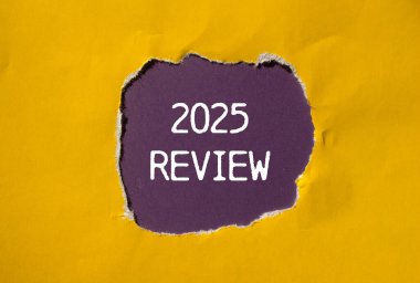 Yırtık sarı kağıda mor arkaplan ile yazılmış 2025 gözden geçirme mesajı. Kavramsal 2025 değerlendirme sembolü. Boşluğu kopyala.