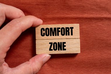 Comfort zone message written on wooden blocks with brown background. Conceptual comfort zone symbol. Copy space. clipart