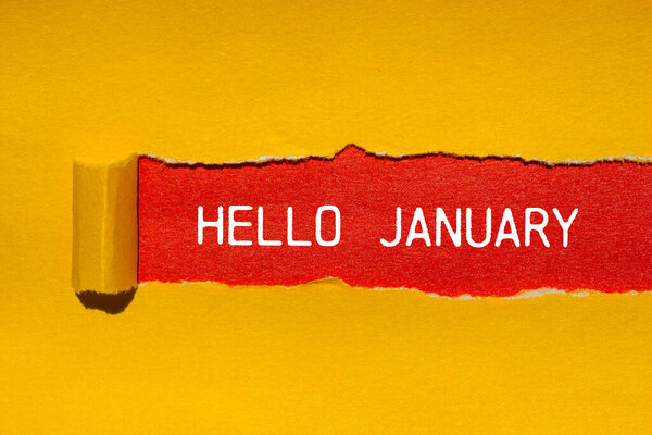 Hello january message written on ripped torn yellow paper with red background. Conceptual hello january symbol. Copy space.