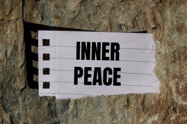 Yırtık kağıt parçasına taş kapaklı iç barış mesajı. Kavramsal iç huzur sembolü. Boşluğu kopyala.