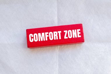 Tahta kırmızı blokta beyaz arkaplan ile yazılmış rahat bölge mesajı. Kavramsal konfor bölgesi sembolü. Boşluğu kopyala.