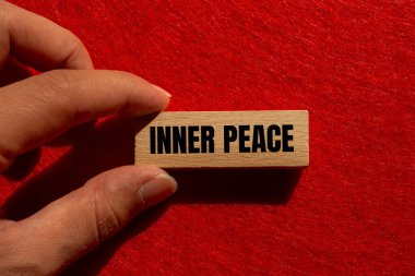 Ahşap blokta kırmızı arka planda yazılmış iç barış mesajı. Kavramsal iç huzur sembolü. Boşluğu kopyala.