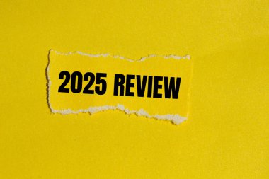 Sarı arkaplanlı yırtık sarı kağıt parçasına yazılmış 2025 gözden geçirme mesajı. Kavramsal 2025 değerlendirme sembolü. Boşluğu kopyala.