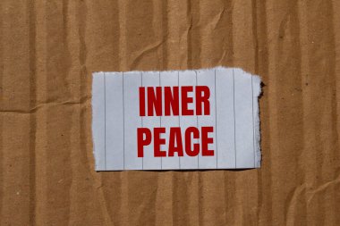 Karton kapaklı yırtık kağıt parçasına yazılmış iç barış mesajı. Kavramsal iç huzur sembolü. Boşluğu kopyala.