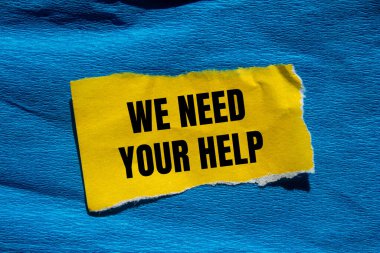 Yırtık sarı kağıt parçasına mavi arkaplanlı yardım mesajına ihtiyacımız var. Kavramsal olarak yardım sembolüne ihtiyacımız var. Boşluğu kopyala.