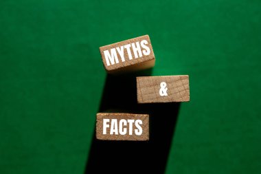 Efsaneler ve gerçekler yeşil arka planlı tahta bloklara yazılmış. Kavramsal mitler ve gerçekler sembolü. Boşluğu kopyala.