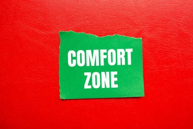 Kırmızı arka planlı yırtık yeşil kağıt parçasına konforlu bölge mesajı yazılmış. Kavramsal konfor bölgesi sembolü. Boşluğu kopyala.