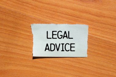 Tahta kapaklı yırtık kağıt parçasına yazılmış yasal tavsiye mesajı. Kavramsal hukuki tavsiye sembolü. Boşluğu kopyala.