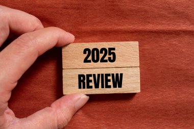 Kahverengi arka planlı ahşap bloklara yazılmış 2025 gözden geçirme mesajı. Kavramsal 2025 değerlendirme sembolü. Boşluğu kopyala.