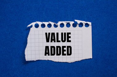 Value added message written on ripped torn paper piece with blue background. Conceptual value added symbol. Copy space. clipart