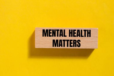 Mental health matters message written on wooden block with yellow background. Conceptual mental health matters symbol. Copy space. clipart